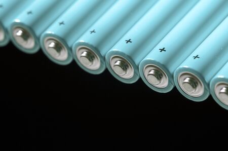 set of AA batteries lined up on a black  backgroundの写真素材