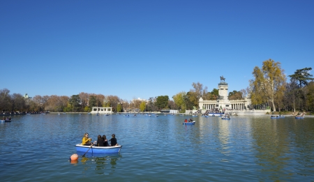 Madrid, Spain - December 8, 2012: Tourists walking in rowboat on Lake Buen Retiro park. This park is the largest in the city and close to the tourist area of Old Town. In the background you can see the monument to King Alfonso XII.のeditorial素材