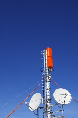 closeup of a television and radio repeater with a clear blue skyの写真素材