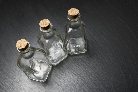 small empty bottles on a black slateの写真素材