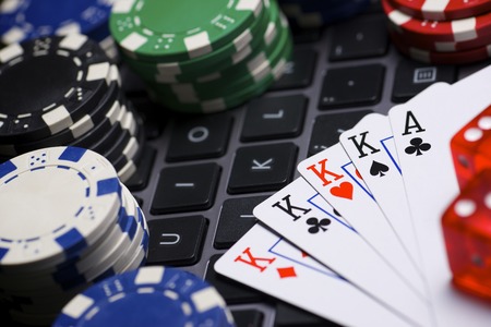 Casino chips, cards and dices stacking on a laptop