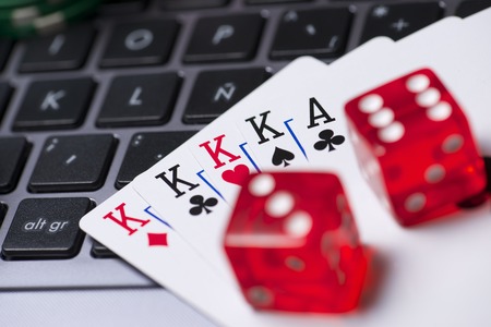 Casino chips, cards and dices stacking on a laptopの写真素材