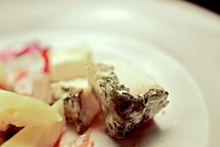 Lots of assorted cheese on a white table.