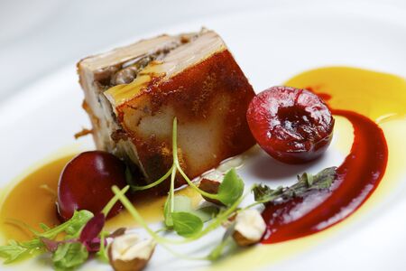 Piglet with cherries in a white plate.の写真素材