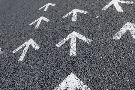 Directional arrows painted on a cement floor.
