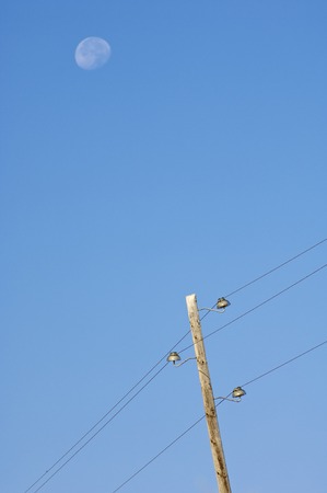 Wooden pylon with blue sky and moonの写真素材