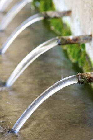 Jets of water coming through the pipes of an old fountain, Pnarroya de Tastavins, Teruel, Aragon,...