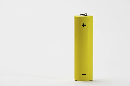 Yellow battery on a white table.の写真素材