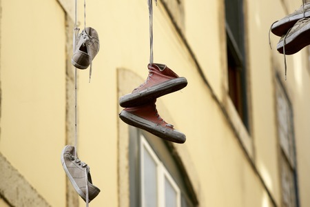 Old sneakers hanging from a cable.の写真素材