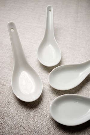 Small white spoons on a white tableclothの写真素材