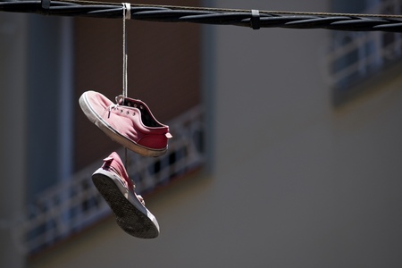Old sneakers hanging from a cable.の写真素材