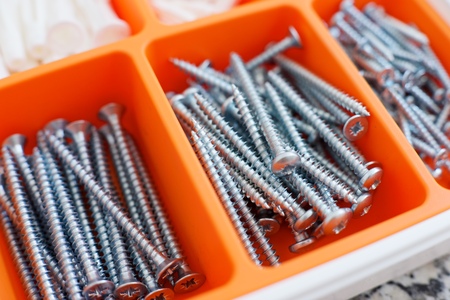 Screws and dowels on an orange box.の写真素材