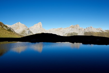 Peaks reflected in Ansabere Lake. Lescun Cirque. Aspe Valley, Pyrenees, France.
