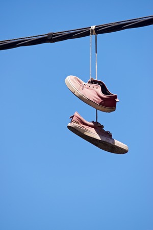 Old sneakers hanging from a cable.の写真素材