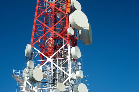 Telecommunications tower with clear blue sky.