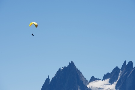 Paragliding flying over Mont Blanc Massif, in the background are Aiguilles du Chamonix, Alps, Chamonix, Franceの写真素材