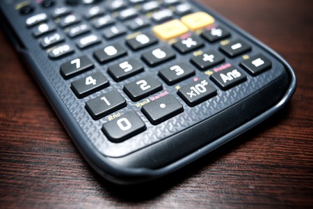 Scientific calculator close up on a wood table.の写真素材