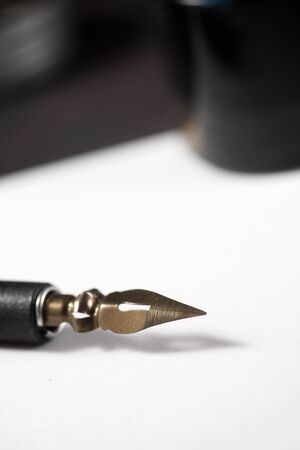 Nib pen for calligraphy and inkwell on a table.の写真素材
