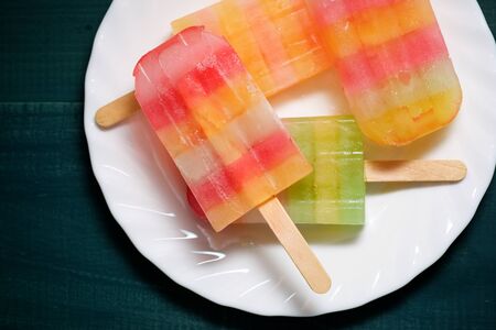 Popsicles on a wood table.
