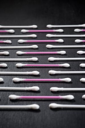 Ear swabs on a black table.