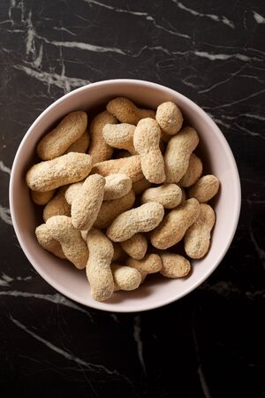 Peanuts with shell on a table.