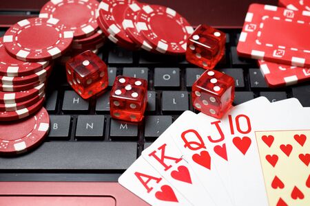 Casino chips, cards and dices stacking on a laptop