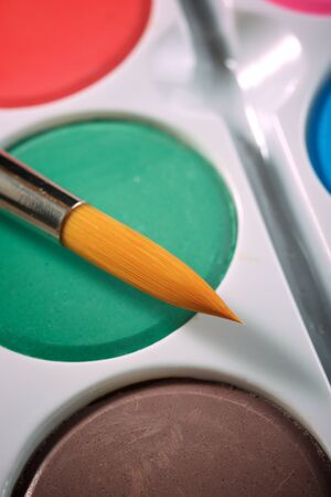 Box of watercolors and brush on a table.の写真素材