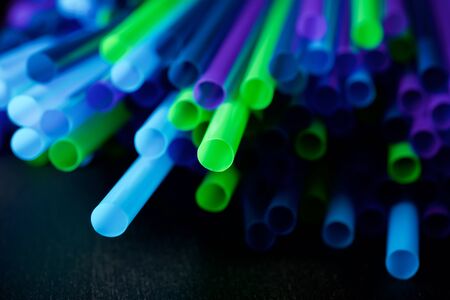 Drinking plastic straws on a black table.の写真素材