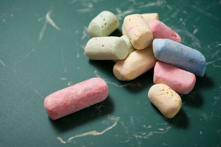 View of a group of chalks and a green blackboard.