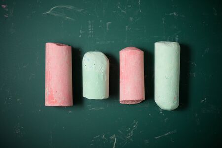 View of a group of chalks and a green blackboard.の写真素材