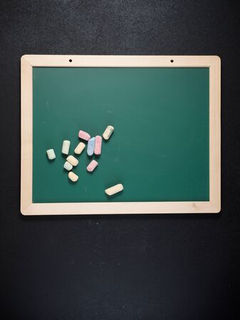 View of a group of chalks and a green blackboard.の写真素材
