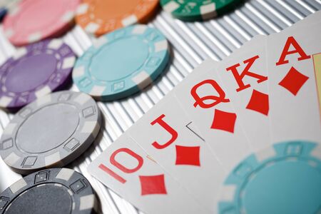 Cards and casino chips on a metal surface.