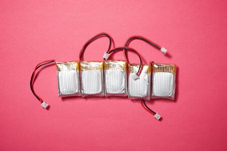 Drone batteries on a pink table.