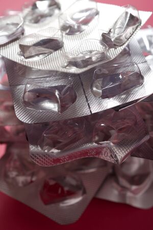 Empty blisters pack on a pink surface.