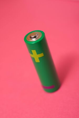 Small battery on a pink table.