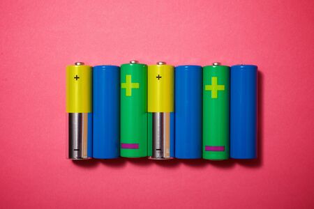 Small batteries on a pink table.の写真素材