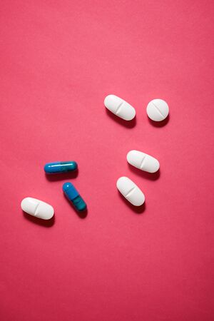 Pills on a pink table.の写真素材