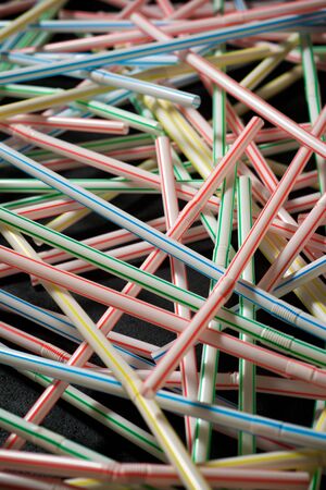 Drinking plastic straws on a black table.の写真素材