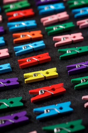 Small clothespins on a black table.