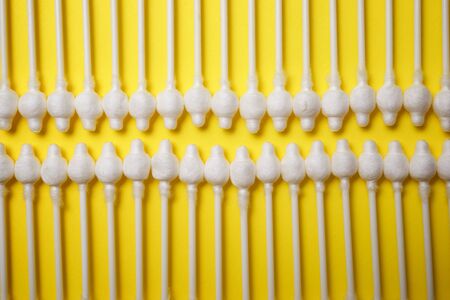 Ear swabs on a yellow table.の写真素材