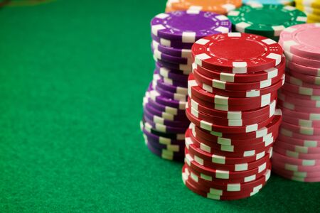 View of a gaming table with green mat and casino chips.