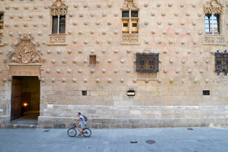 Salamanca, Spain - July 4, 2017: cyclist passing in front of the House of the Shells, named Casa de las Conchas.のeditorial素材