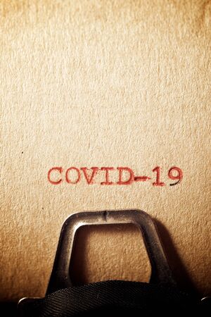 Covid-19 word written on a paper.の写真素材