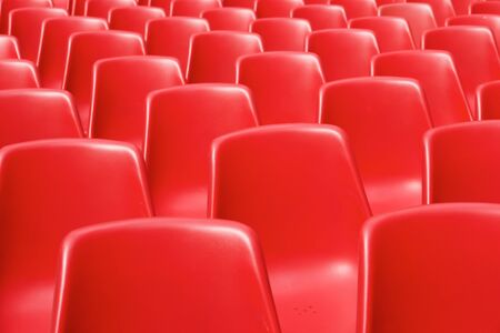 Huge group of red plastic chairs.