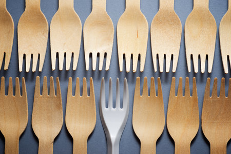 Disposable wooden and plastic cutlery on a table.