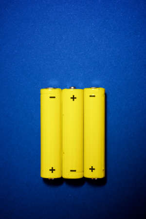 Small batteries on a blue table.の写真素材