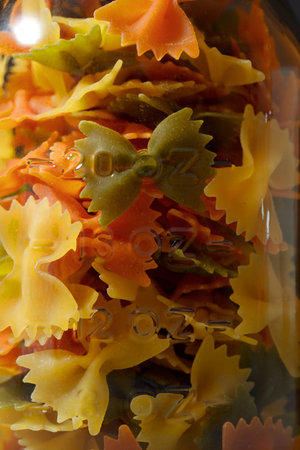Glass jar full of ties pasta, on a stone table.の写真素材