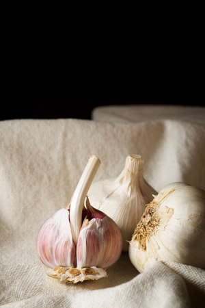 Garlic cloves on a white tablecloth.の写真素材