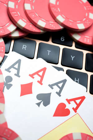 Casino chips and cards stacking on a laptop.の写真素材