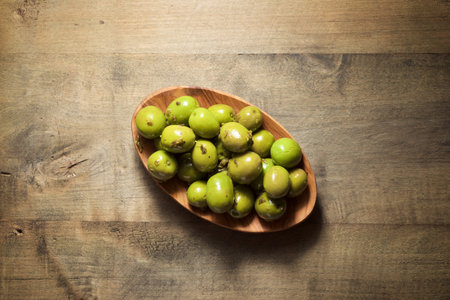 Typical Spanish olives on a wooden plate.の写真素材